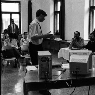 Early computer training session with instructor and students.