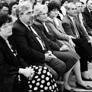 Group of people attending formal indoor meeting or conference.