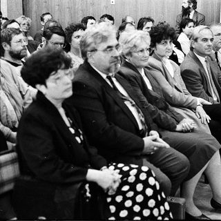 Group of people attending formal indoor meeting or conference.