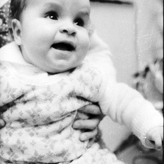 Baby in cozy outfit, looking surprised.