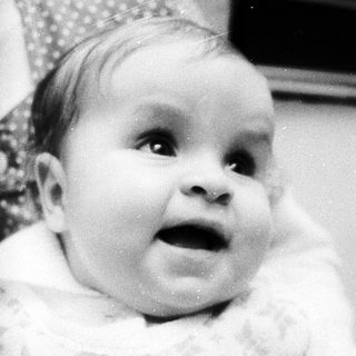 Baby in cozy outfit, looking surprised.