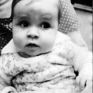Baby in soft knit garment looking directly at camera.
