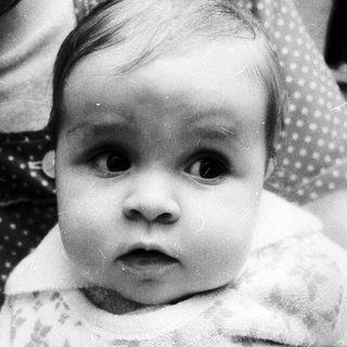 Baby in soft knit garment looking directly at camera.