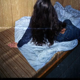 Person lying on bed with head down.