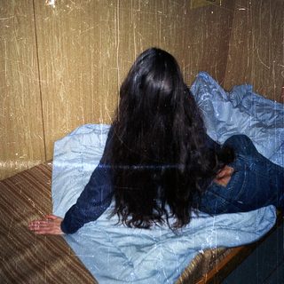 Person lying on bed with head down.