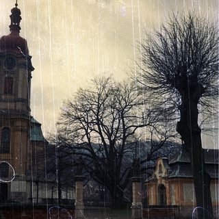 Rainy view of historic building through wet window.