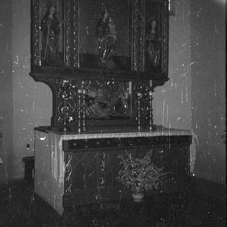 Elegant altar with religious paintings and candlelit shrine.
