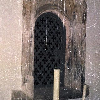 Gothic-style window with lit candles below.