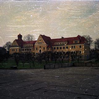 Large historic building with red roof.