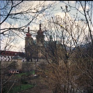 Baroque church towers framed by winter trees.