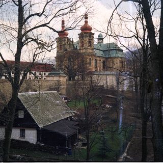 Baroque church with twin towers in winter landscape.