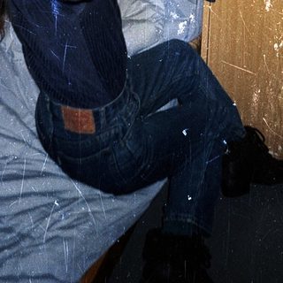 Person sitting on bed near radiator.