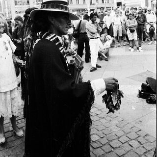 Street musician performing traditional music outdoors.