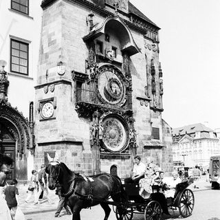 Historic astronomical clock with horse-drawn carriage.