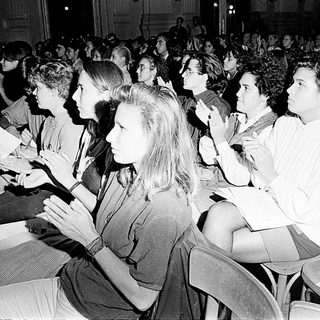 Large audience attentively participating in indoor event.