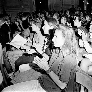 Large audience attentively participating in indoor event.