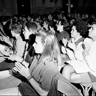 Crowded indoor lecture or event audience listening attentively.