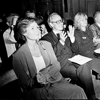 People attending a formal indoor event, clapping.