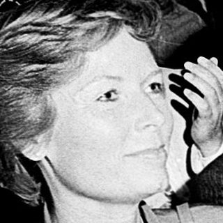 People attending a formal indoor event, clapping.
