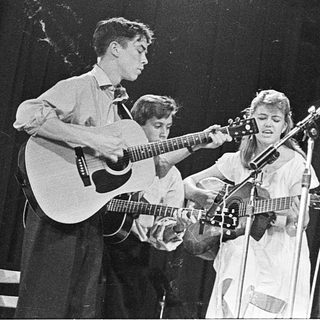 Band performing live with guitars and vocals.