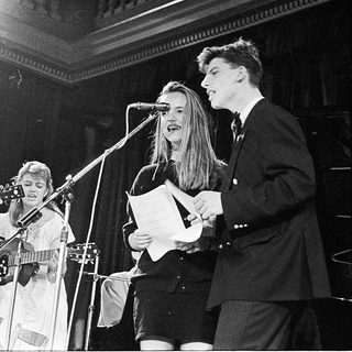 Band performing live with guitars and vocals.