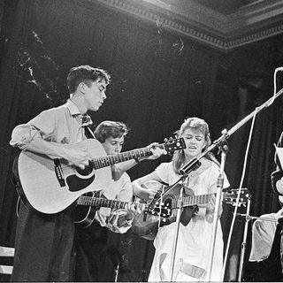 Band performing live with guitars and vocals.