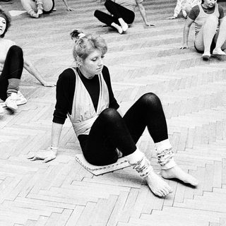 Group dance class in progress on wooden floor.