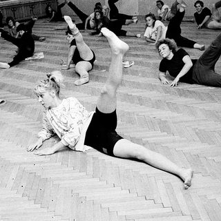 Group fitness class performing floor exercises.