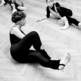 Dance class with students practicing floor exercises.