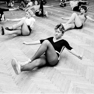 Group stretching exercise in dance studio.