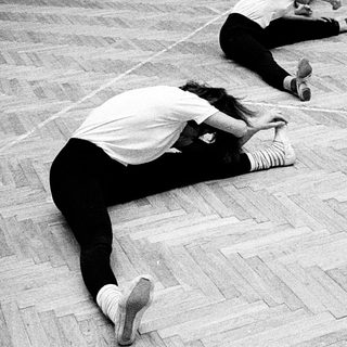 Group performing floor exercises in dance studio.