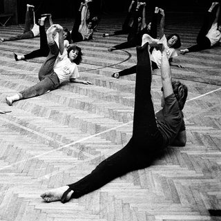Group practicing contemporary dance stretches indoors.