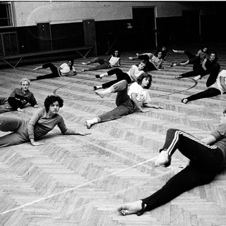 Group fitness class performing floor exercises.