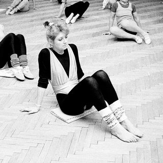 Dance class in progress, students practicing floor exercises.