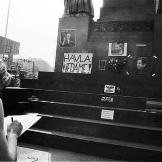 Woman signing protest banner near monument.