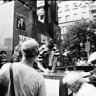 People signing a wall memorial.
