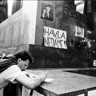 Man signing a memorial wall with "Havel nedáme" (We do not forget).