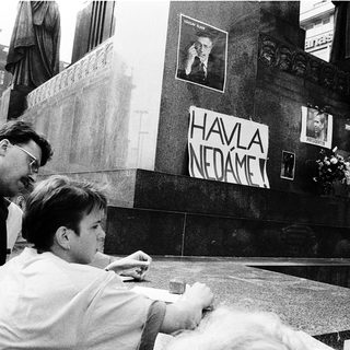 People paying respects at memorial with "Havel nedáme" sign.