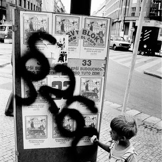 Child touches vandalized billboard with graffiti.