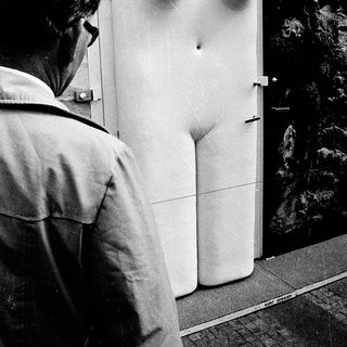 Man inspecting refrigerator with frost-covered interior.