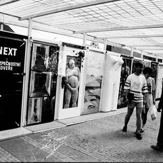 Outdoor photo exhibition with security entrance.