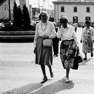 Women walking past political campaign poster.
