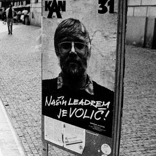 Women walking past political campaign poster.