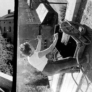 Two women on a rooftop: one standing, one mid-dive.