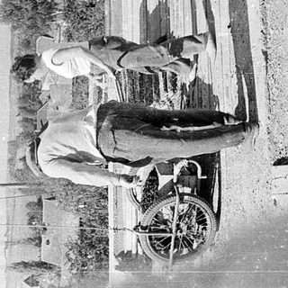 Two men performing skateboard tricks on wooden rails.