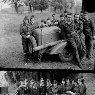 Military personnel posing with vintage motorcycle and sidecar.