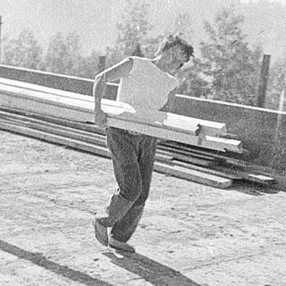 Two men playing frisbee on rooftop.