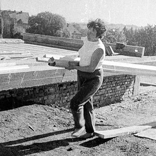 Two men playing frisbee on rooftop.