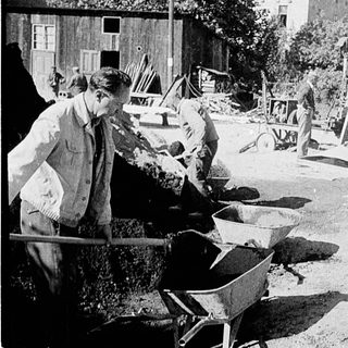 Historical construction workers using manual tools.
