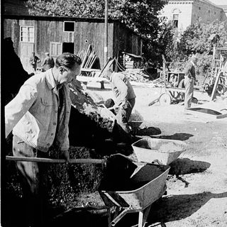 Historical construction workers using manual tools.